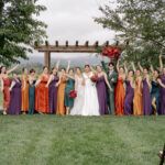 An image of a bride together with her bridesmaids in a scenic venue surrounded by trees.