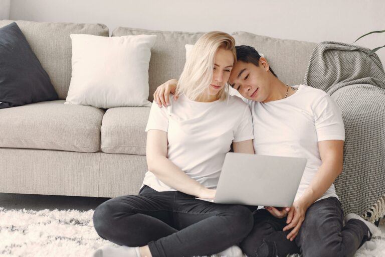Man And Woman In White Crew Neck Shirt Looking At A Laptop